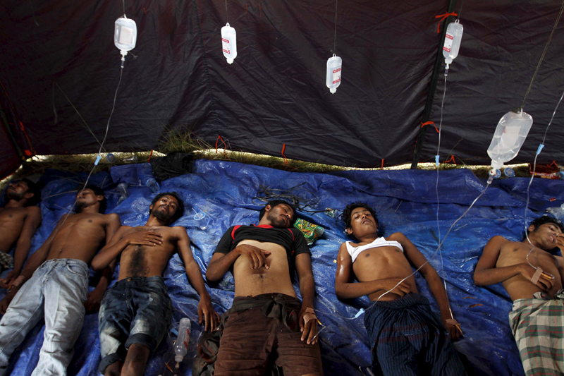 Rohingya and Bangladeshi migrants who arrived in Indonesia by boat receive medical assistance at an aid station in Kuala Langsa in Indonesia's Aceh Province on May 15, 2015. Nearly 800 "boat people" were brought ashore in Indonesia on Friday, but other vessels crammed with migrants were sent back to sea despite a UN call to rescue thousands adrift in Southeast Asian waters with dwindling supplies of food and water. Photo courtesy of REUTERS/Roni Bintang *Editors: This photo may only be republished with RNS-ROHINGYA-SPLAINER, originally transmitted on May 19, 2015.