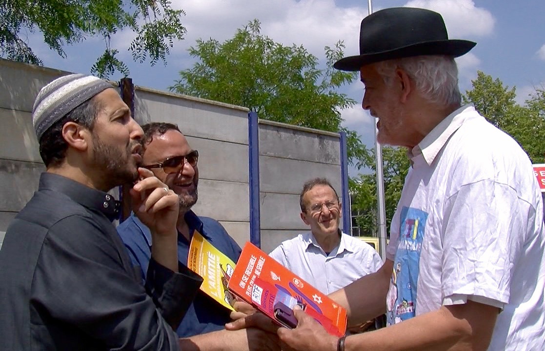 Rabbi Michel Serfaty speaks to Muslim men outside UOIF headquarters.  Religion News Service photo by Elizabeth Bryant