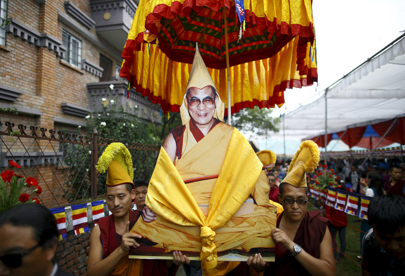 Tibetan monks carry a portrait of Dalai Lama during his 80th birthday celebrations in Kathmandu on July 6, 2015. Nepal ceased issuing refugee papers to Tibetans in 1989 and recognizes Tibet to be a part of China. Photo courtesy of REUTERS/Navesh Chitrakara