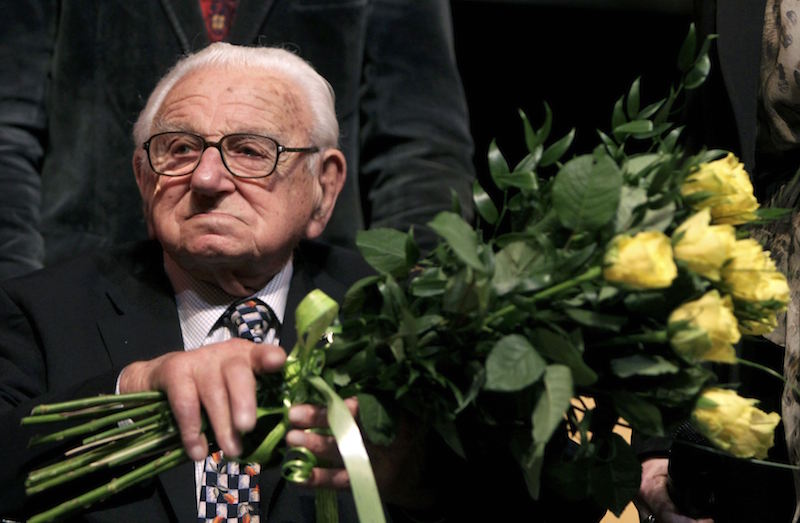 Nicholas Winton, aged 101, holds flowers while sitting on a stage after the premiere of the movie 