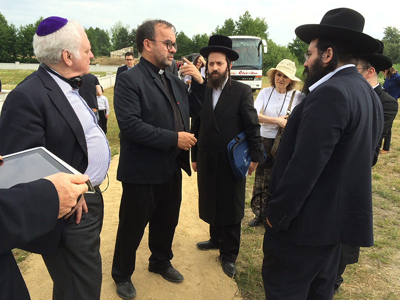 Father Patrick Desbois, second from left, greets visitors at Rava Ruska Holocaust mass grave on June 29, 2015. Desbois found and documented nearly 1700 Jewish mass graves in Ukraine and elsewhere in Eastern Europe. Religion News Service photo by Michael Scaturro