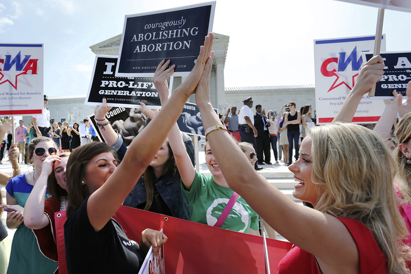 Anti-abortion demonstrators high five as the ruling for Hobby Lobby was announced outside the U.S. Supreme Court in Washington on June 30, 2014. Photo courtesy of REUTERS/Jonathan Ernst 
*Editors: This photo may only be republished with RNS-WINDHAM-COLUMN, originally transmitted on July 2, 2015.