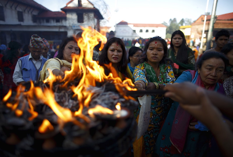 Devotees offer lamps while offering prayers at Pashupatinath temple to mark the Shrawan Sombar festival in Kathmandu July 27, 2015. The festival lasts for a month, during which devotees fast and worship Lord Shiva to pray for happiness for their families. Photo courtesy REUTERS/Navesh Chitrakar  