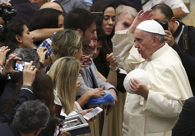 Pope Francis changes his cap with a faithful during his Wednesday general audience in Paul VI hall at the Vatican on August 19, 2015. Photo courtesy of REUTERS/Alessandro Bianchi
*Editors: This photo may only be republished with RNS-AMBASSADOR-SECURITY, originally transmitted on August 25, 2015.