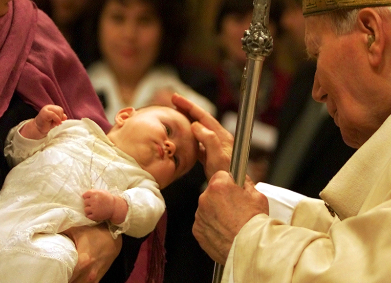 Pope John Paul II blesses baby Faustine Frichot during a special baptism ceremony in the Sistine Chapel on January 13, 2002. Photo courtesy of REUTERS BOOKS Pope John Paul II Reaching Out Across Borders, REUTERS/Dylan Martinez *Editors: This photo may only be republished with RNS-BABY-BONUS, originally transmitted on August 11, 2015.