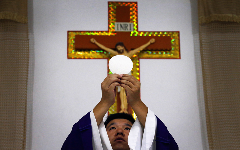 Catholic priest Liu Yong Wang performs holy communion in a make-shift chapel in the village of Bai Gu Tun, located on the outskirts of the city of Tianjin, around 70 km (43 miles) south-east of Beijing on July 17, 2012. Photo courtesy of REUTERS/David Gray