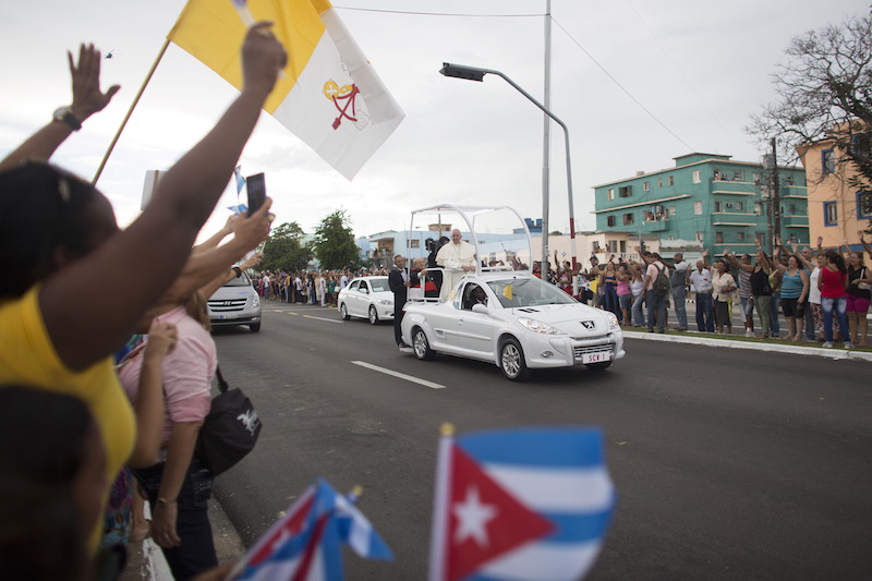 People react as Pope Francis arrives at the airport in Havana, Sept 19, 2015. Pope Francis begins a nine-day tour of Cuba and the United States on Saturday where he will see both the benefits and complexities of a fast-evolving detente between the old Cold War foes that he helped broker. Photo courtesy Alexandre Meneghini 