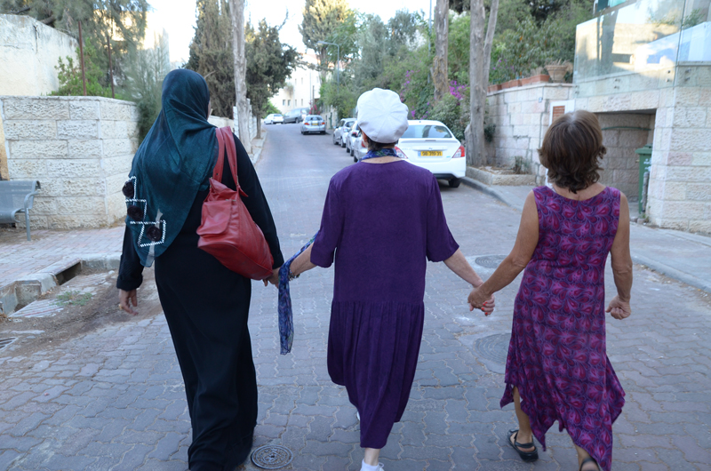 Three women, including Elana Rozenman, Abrahamic Reunion co-founder and founder of TRUST-Emun, center, hold hands during the interfaith peace walk between the eastern and western parts of Jerusalem on Sept. 21, 2015 after an interfaith group gathering between Jews and Muslims. Photo courtesy of The Abrahamic Reunion