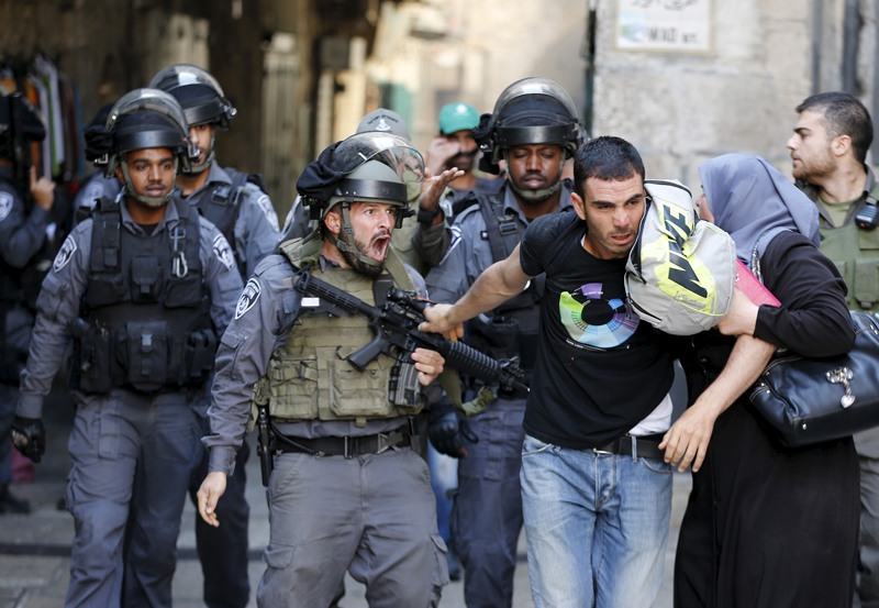 An Israeli policeman prevents a Palestinian man from entering the compound which houses al-Aqsa mosque, known by Muslims as the Noble Sanctuary and by Jews as the Temple Mount, in Jerusalem's Old City on September 28, 2015. Photo courtesy of REUTERS/Ammar Awad