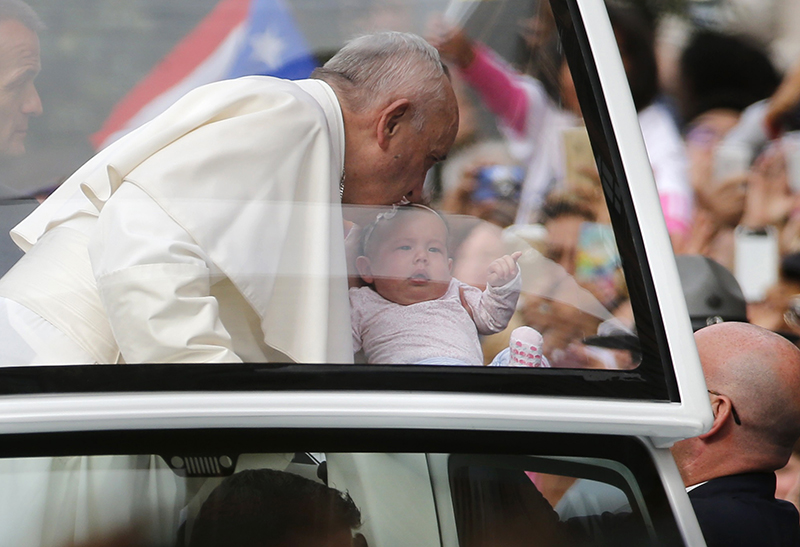 qPope Francis bends over to kiss a small child as he arrives at Independence Mall where he was to deliver remarks on the theme "We Hold These Truths," a quote from the U.S. Declaration of Independence, in front of Independence Hall in Philadelphia, on September 26 2015. Photo courtesy of REUTERS/Jim Bourg *Editors: This photo may only be republished with RNS-POPE-FAMILIES, originally transmitted on Sept. 26, 2015.