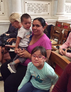 Irene Avalos, who came to Washington from Guatamala 9 years ago, and her two children, Jeffrey, age 2, and Katerina, age 6, were invited by the Spanish ministry at St. Matthews to greet Pope Francis outside but were treated to prime inside seats instead. The family awaits the Pope's visit to the church on Sept. 23, 2015. Religion News Service photo by Cathy Lynn Grossman
