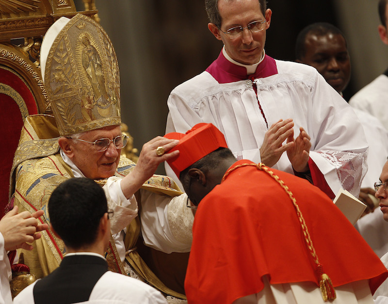New cardinal Robert Sarah of Guinea receives the red biretta, a four-cornered red hat, from Pope Benedict XVI during the Consistory ceremony in Saint Peter's Basilica at the Vatican November 20, 2010. Photo courtesy REUTERS/Tony Gentile 
