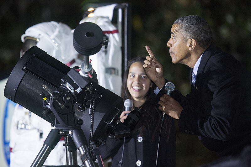 U.S. President Barack Obama points at the moon after looking at it through a telescope with Agatha Sofia Alvarez-Bareiro, a high school senior from Brooklyn, New York, during the second White House Astronomy Night on the South Lawn of the White House in Washington on October 19, 2015. Photo courtesy of REUTERS/Joshua Roberts