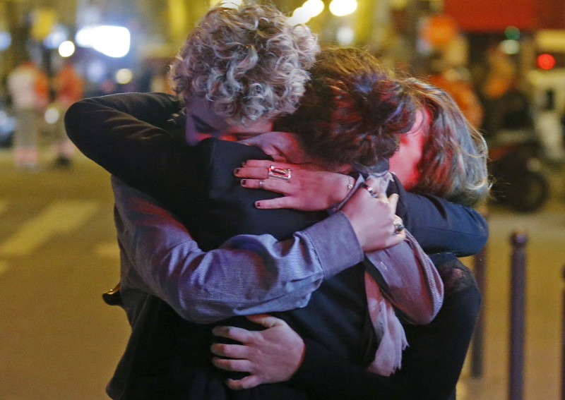People hug on the street near the Bataclan concert hall following fatal attacks in Paris, France, November 14, 2015. Gunmen and bombers attacked busy restaurants, bars and a concert hall at locations around Paris on Friday evening, killing dozens of people in what a shaken French President described as an unprecedented terrorist attack. REUTERS/Christian Hartmann - RTS6X48