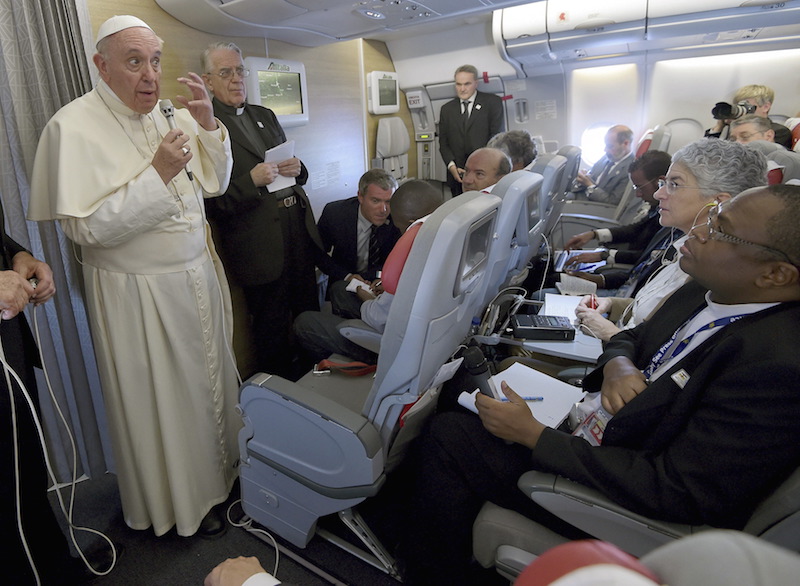 Pope Francis gestures during a meeting with the media onboard the papal plane while en route to Rome, Italy, November 30, 2015.  Photo courtesy REUTERS/Daniel Dal Zennaro/pool 