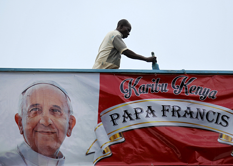 A volunteer paints the wall near a banner of Pope Francis at at the University of Nairobi grounds ahead of the Papal Mass in Kenya's capital Nairobi, on November 24, 2015. Photo courtesy of REUTERS/Thomas Mukoya
*Editors: This photo may only be republished with RNS-POPE-AFRICA, originally transmitted on Nov. 24, 2015.