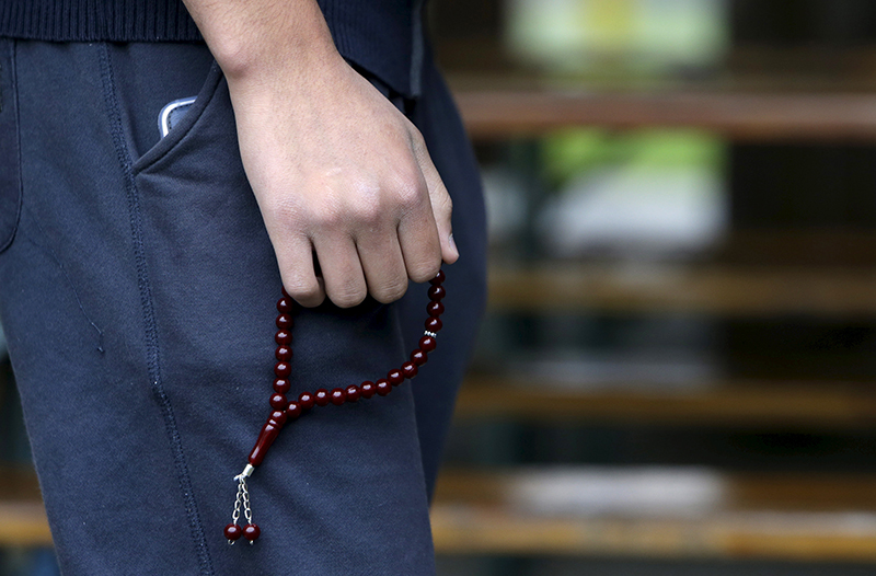 A Syrian migrant, who said he was pressured by Austria to leave the country for Slovakia, holds prayer beads in front of a building acting as a temporary refugee camp in Gabcikovo, Slovakia, on October 8, 2015. Photo courtesy of REUTERS/David W Cerny
*Editors: This photo may only be republished with RNS-REFUGEES-RELIGION, originally transmitted on Nov. 18, 2015.