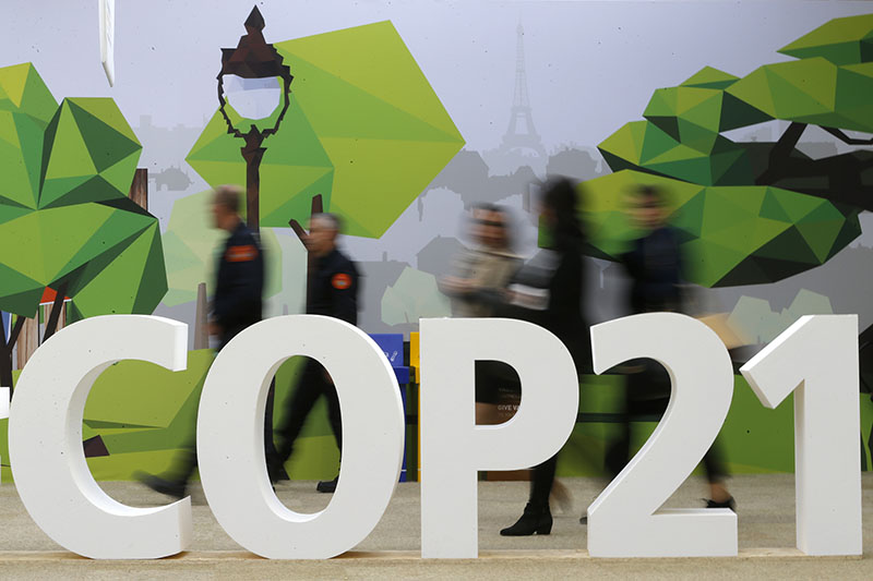 People walk walks past the COP21 logo in the Climate Generations area during the World Climate Change Conference 2015 (COP21) at Le Bourget, near Paris, France, on December 1, 2015. Photo courtesy of REUTERS/Stephane Mahe *Editors: This photo may only be republished with RNS-KAYLOR-COLUMN, originally transmitted on Dec. 2, 2015.