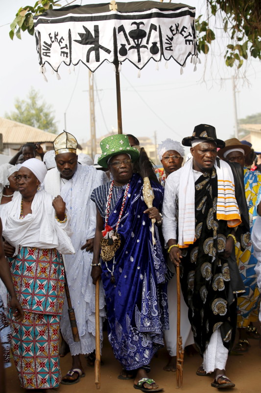 Voodoo chief priest Dagbo (C) walks with other devotees during a traditional street procession at the beginning of the annual voodoo festival in Ouidah, Benin, January 10, 2016. REUTERS/Akintunde Akinleye.