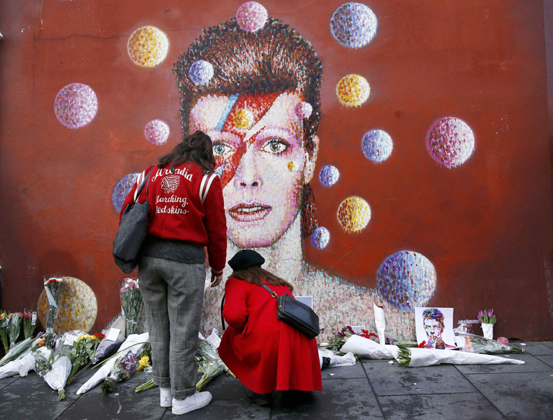 Two women stop at a mural of David Bowie in Brixton, south London, on January 11, 2016. David Bowie, a music legend died of cancer. Photo courtesy of REUTERS/Stefan Wermuth *Editors: This photo may only be republished with RNS-BOWIE-FAITH, originally transmitted on Jan. 11, 2016.