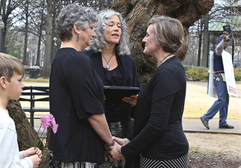 A protester waving a bible walks past in the background as two women named Donna and Tina get married in a park outside the Jefferson County Courthouse in Birmingham, Alabama, on February 9, 2015. Photo courtesy of  REUTERS/Marvin Gentry
*Editors: This photo may only be republished with RNS-CALDWELL-COLUMN, originally transmitted on Jan. 7, 2016.