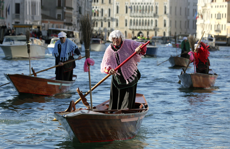 Men dressed as "La Befana", an imaginary old woman who is thought to bring gifts to children during the festival of Epiphany, row boats down the Grand Canal in Venice, on January 6, 2012. The orthodox Christian holiday of Epiphany is observed as the date when the Three Wise Men visited baby Jesus. Photo courtesy of REUTERS/Manuel Silvestri *Editors: This photo may only be republished with RNS-EPIPHANY-BEFANA, originally transmitted on Jan. 5, 2016.
