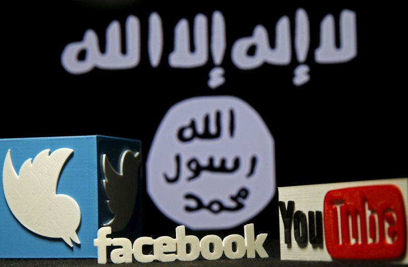 A 3D plastic representation of the Twitter and Youtube logo is seen in front of a displayed ISIS flag in this photo illustration in Zenica, Bosnia and Herzegovina, February 3, 2016. REUTERS/Dado Ruvic.