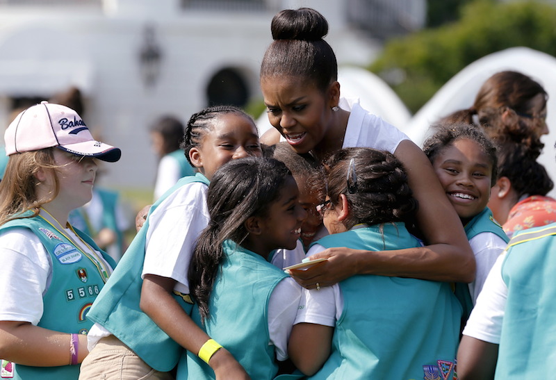U.S. first lady Michelle Obama (C) gives out hugs as she welcomes a group of Girl Scouts to the White House. The Archbishop of St. Louis has warned Catholics that the scouts do not align with Catholic values. REUTERS/Jonathan Ernst 
