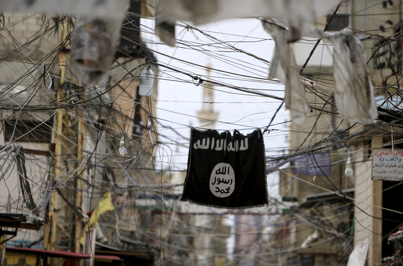 An Islamic State flag hangs amid electric wires over a street in Ain al-Hilweh Palestinian refugee camp, near the port-city of Sidon, southern Lebanon on January 19, 2016. Photo courtesy of REUTERS/Ali Hashisho