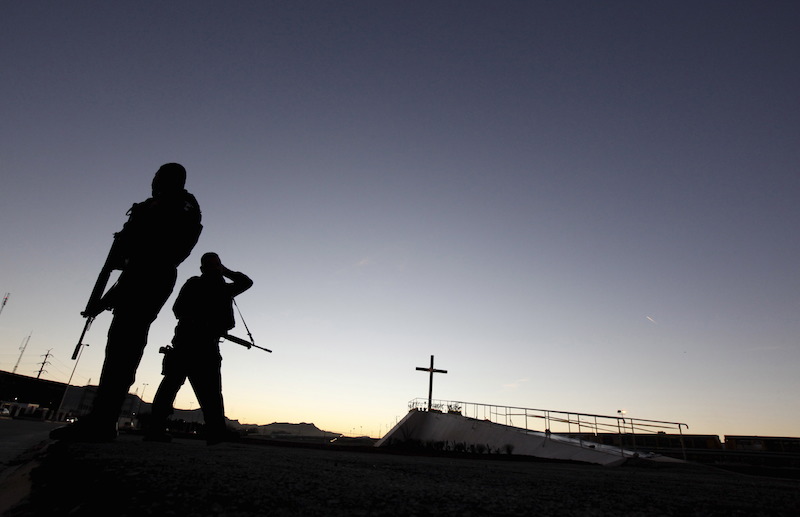 Police officers stand guard next to a cross where Pope Francis will celebrate Mass in Ciudad Juarez, Mexico, February 15, 2016. REUTERS/Jose Luis Gonzalez TPX IMAGES OF THE DAY - RTX273JY