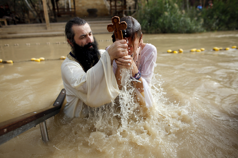 A Christian pilgrim is baptised as she takes part in a ceremony at the baptismal site known as Qasr el-Yahud on the banks of the Jordan River, near the West Bank city of Jericho on January 18, 2016. Thousands of Orthodox Christians flocked to the Jordan River to celebrate the feast of the Epiphany at the traditional site where it is believed John the Baptist baptised Jesus. Photo courtesy of REUTERS/Nir Elias *Editors: This photo may only be republished with RNS-ISRAEL-POLL, originally transmitted on March 8, 2016.