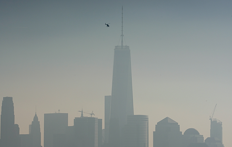 A helicopter flies over the Hudson River with One World Trade Center and Lower Manhattan in the background, on a hazy day in New York City, on December 6, 2015. Photo courtesy of REUTERS/Rickey Rogers *Editors: This photo may only be republished with RNS-POHLMANN-OPED, originally transmitted on March 11, 2016.