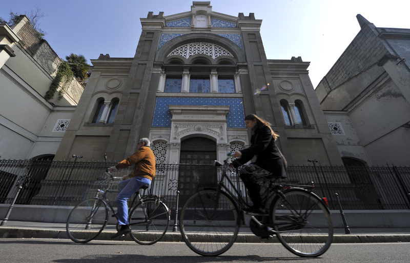 Two people ride bicycles past a synagogue in Milan, Italy on March 15, 2012. Photo courtesy of REUTERS/Paolo Bona 
*Editors: This photo may only be republished with RNS-TALMUD-ITALIAN, originally trasmitted on March 30, 2016.
