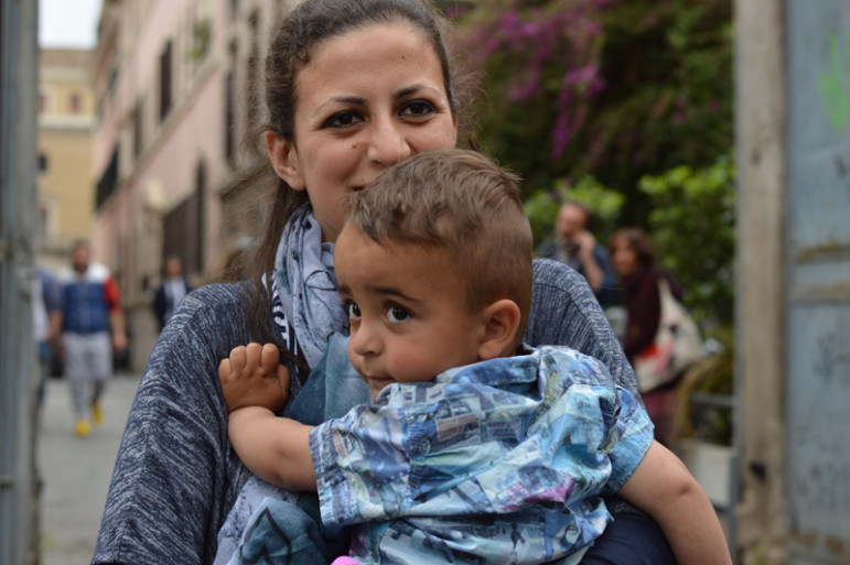 The youngest Syrian refugee aboard the papal plane was 2-year-old Riyad, carried here by his mother Nour. Religion News Service photo by Rosie Scammell