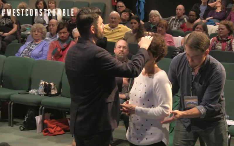 Charlie Shamp prays over a woman March 3 at the Seattle Revival Center. The man in back of her is known as a “catcher” in case she falls to the ground. Photo courtesy of Julia Duin