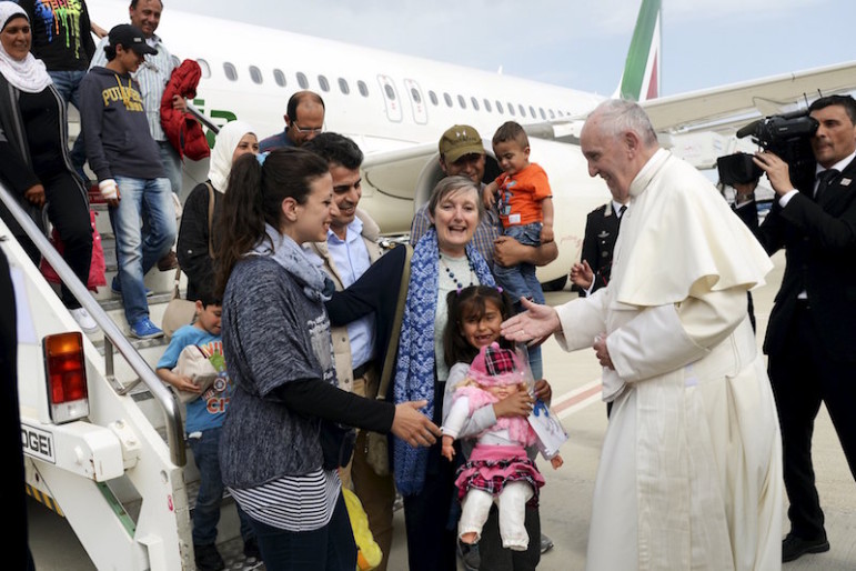 Pope Francis welcomes a group of Syrian refugees after they landed at Ciampino airport in Rome, following a visit at the Moria refugee camp in the Greek island of Lesbos, April 16, 2016. (Filippo Monteforte/Pool Photo via AP)