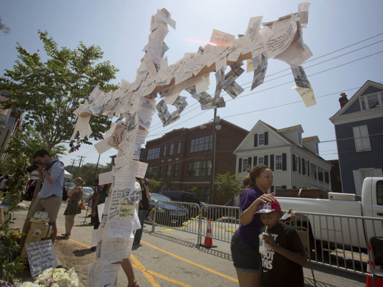 A mother and son stand at a makeshift memorial for victims of a mass shooting, outside the Emanuel African Methodist Episcopal Church in Charleston, on June 22, 2015. Photo courtesy of REUTERS/Carlo Allegri
