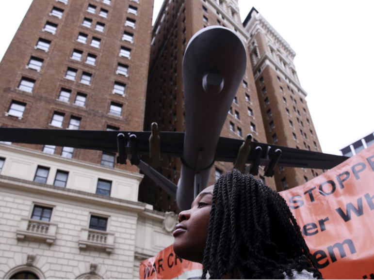 A woman listens to speakers below a model of a drone at a demonstration to protest overseas wars the United States is involved in and actions of U.S. Republican presidential candidate Donald Trump in New York on March 13, 2016. Photo courtesy of REUTERS/Lucas Jackson 
*Editors: This photo may only be republished with RNS-CAMOSY-COLUMN, originally transmitted on May 3, 2016.