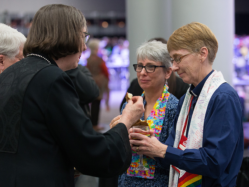 Bishop Elaine Stanovsky (left foreground) receives Holy Communion from Sue Laurie (right) and Julie Bruno during opening worship at the 2016 United Methodist General Conference in Portland, Ore. Laurie and Bruno, prominent activists for greater inclusion of gays and lesbians in the life of The United Methodist Church, were married outside the 2008 General Conference in Fort Worth, Texas. Photo by Mike DuBose, UMNS