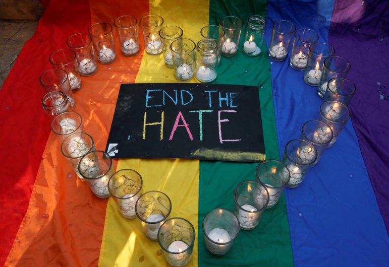 University of the Philippines students display glasses with lit candles and a placard as a tribute to those killed in the Pulse nightclub mass shooting in Orlando, during a protest at the school campus in Quezon city, Metro Manila, Philippines on June 14, 2016. Photo courtesy of REUTERS/Erik De Castro