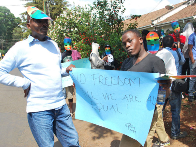 Members of Kenya's gay community hold a sign during a demonstration. Religion News Service photo by Fredrick Nzwili