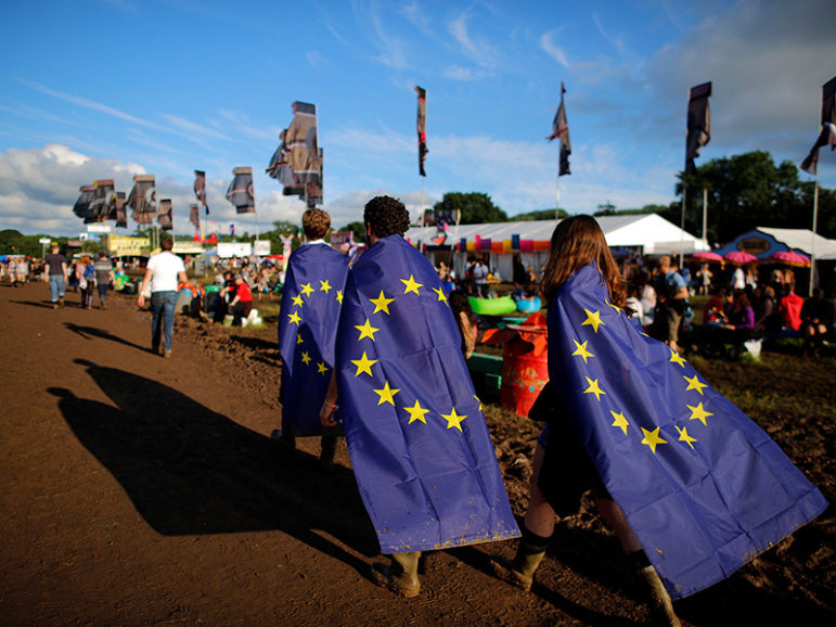 Revelers wrapped in European Union flags walk at Worthy Farm in Somerset during the Glastonbury Festival, Britain, on June 22, 2016. Photo courtesy of REUTERS/Stoyan Nenov