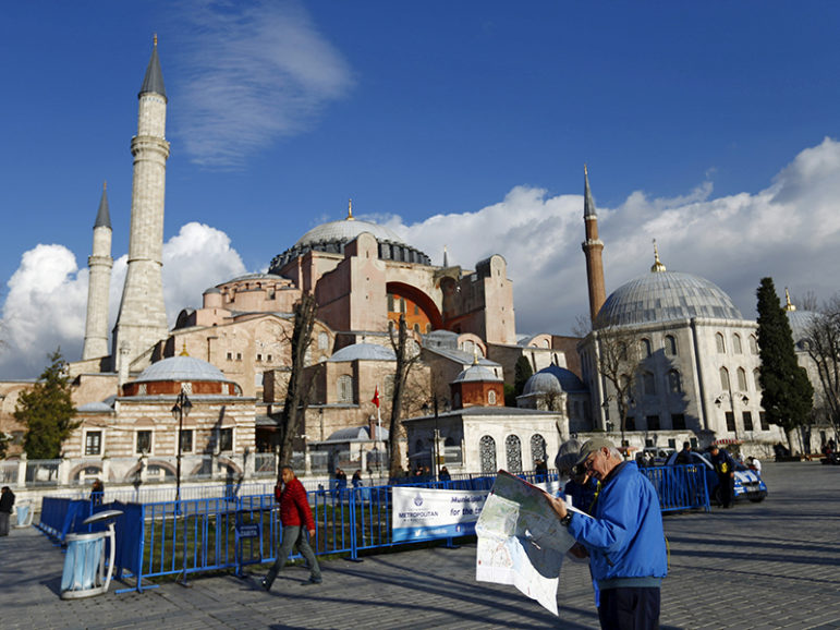 A tourist couple checks a map near the Byzantine-era monument of Hagia Sophia, at Sultanahmet Square in Istanbul, on Jan. 14, 2016. Photo courtesy of REUTERS/Murad Sezer