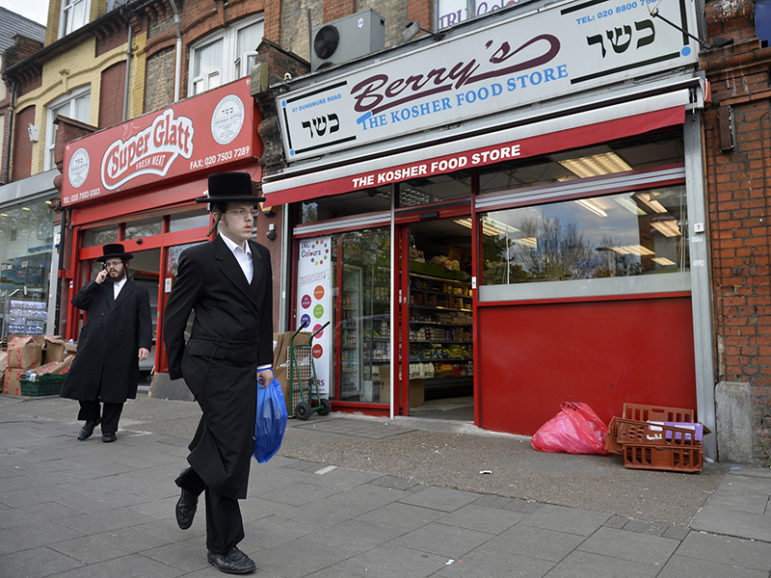 Orthodox Jewish men walk past a row of shops in Stamford Hill, north London, on May 3, 2016. Photo courtesy of REUTERS/Hannah McKay