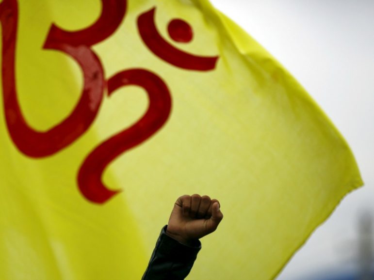 A fist of the Hindu activist is pictured in front of a flag printed with 
