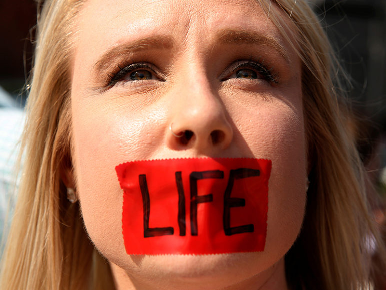 An anti-abortion protester with tape over her mouth demonstrates outside the U.S. Supreme Court in Washington on June 27, 2016. Photo by Kevin Lamarque/Reuters