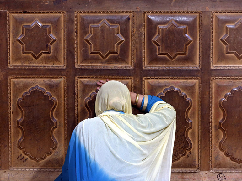 A Muslim woman touches a wooden wall as she prays at the shrine of Sheikh Abdul Qadir Jeelani, a Sufi saint, during the holy fasting month of Ramadan in Srinagar, India, on June 7, 2016. Photo courtesy of Reuters/Danish Ismail