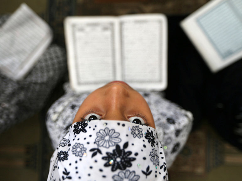 A Palestinian girl reads the Quran during the holy fasting month of Ramadan at a mosque in Rafah in the southern Gaza Strip on June 8, 2016. Photo courtesy of REUTERS/Ibraheem Abu Mustafa*Editors: This photo may only be republished with RNS-RAMADAN-WORLD, originally transmitted on June 9, 2016.