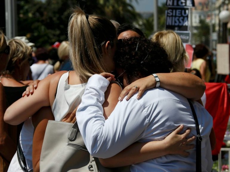 People hug on the Promenade des Anglais during a minute of silence on July 18, 2016, the third day of national mourning to pay tribute to victims of the truck attack along the Promenade des Anglais on Bastille Day that killed scores and injured as many in Nice, France. Photo by Eric Gaillard/REUTERS