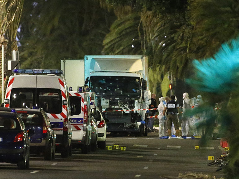French police forces and forensic officers stand next to a truck July 15, 2016 that ran into a crowd celebrating the Bastille Day national holiday on the Promenade des Anglais killing at least 60 people in Nice, France, July 14. Photo courtesy of REUTERS/Eric Gaillard